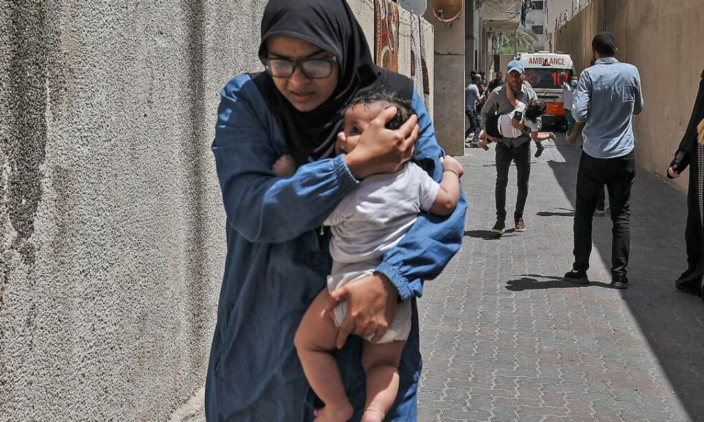 92837270 TOPSHOTPalestinians evacuate a building targeted by Israeli bombardment in Gaza City on